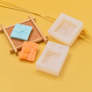 Silicone mold for DIY bow-knot gift box soaps and candles on bright yellow surface