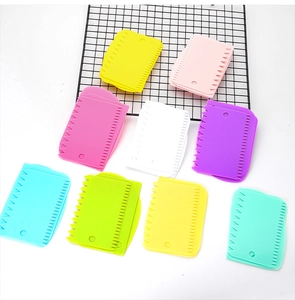 Flat lay of colorful food-grade plastic dough scrapers in various pastel shades for baking