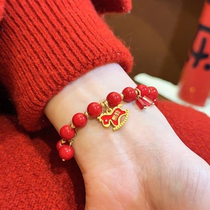 Detailansicht eines vintage roten Achat-Perlenarmbands mit goldenem Pferdanhänger