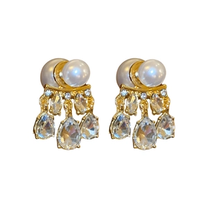 Elegant gold drop earrings with teardrop crystals and faux pearls on white background
