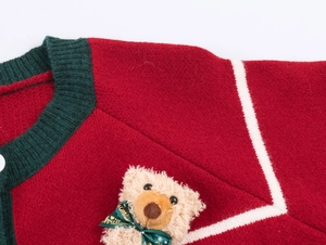 Vue détaillée du cardigan de Noël rouge avec ours en peluche 3D et nœud vert ruban