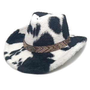 Macro view of plush cow print cowboy hat with braided leather band and bull emblem