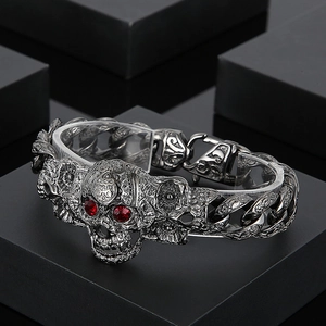 Détail du bracelet tête de mort rétro avec yeux rouges et chaîne à maillons épais