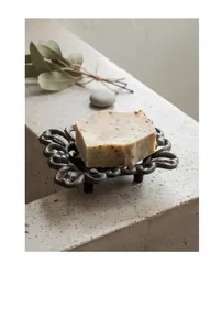 Detail of vintage cast iron soap dish with intricate floral pattern on stone surface