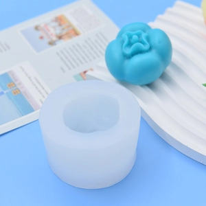 Cylindrical silicone persimmon candle mold with finished blue product on wavy display base