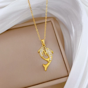Detail of gold dolphin pendant encrusted with sparkling crystals on white silk