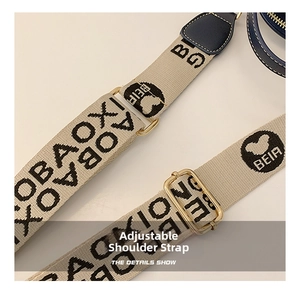Detail of adjustable woven shoulder strap with gold-tone hardware and letter patterns