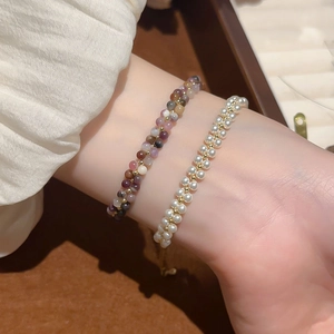 Macro detail of elegant double-layered pearl and purple tourmaline beaded bracelets