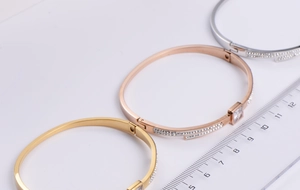 Close-up of tricolor rhinestone bangles in gold, rose gold and silver with size ruler