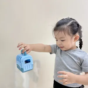 Detail of a child holding the blue toy pet carrier with transparent window and handle