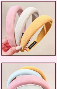 Detail of ribbed sponge headbands in pink, white, yellow, and blue with handmade labels