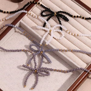 Vue détaillée de colliers en perles noires, blanches et grises avec nœuds métalliques