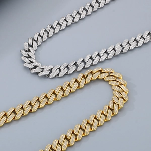 Close-up of gold and silver iced out Cuban link necklaces with shiny crystals