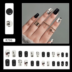 Detail of French minimalist black and white press-on nails with abstract face line art