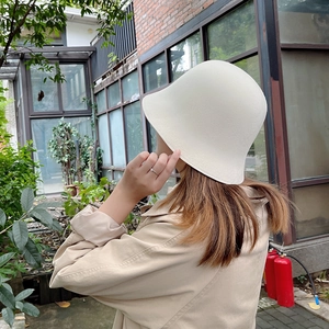 Texture détaillée du bob en feutre de laine crème dans un décor de jardin rustique