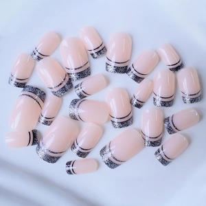 French tip press-on nails with silver glitter and black lines on a light blue background