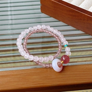 Detailed macro of white crystal bracelet with peaceful buckle and pink beads