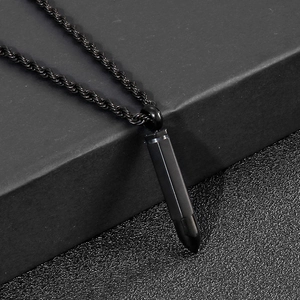 Macro detail of black bullet pendant necklace with twisted rope chain in industrial style