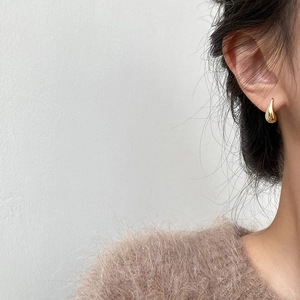 Minimalist two-tone water drop earrings in gold and silver S925 finish worn by a model