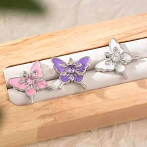 Three enamel butterfly cartilage earrings in pink, purple, and white with crystals