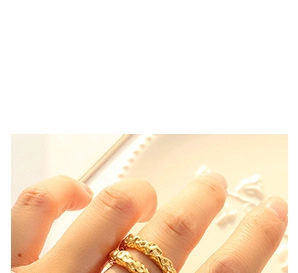 Détail d'une bague en acier titane doré avec une texture martelée irrégulière sur un mannequin