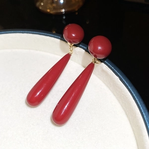Detailed macro view of red teardrop earrings with gold plating and glossy finish