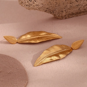 Detailed macro view of 18K gold plated feather leaf earrings with fine texture patterns
