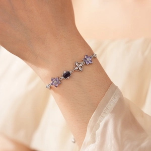 Close-up of elegant zircon flower bracelet on wrist with purple and white gemstones