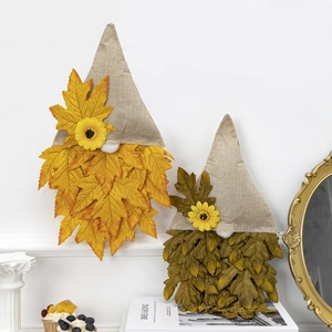 Detail of autumn gnome hanging ornaments with linen hats, maple leaves, and sunflowers