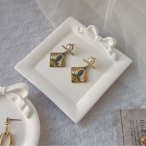 French vintage gold earrings with blue enamel pattern and pearl detail on tray
