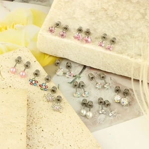 Set of 12 stud earrings featuring pink hearts, pearls and floral designs on stone