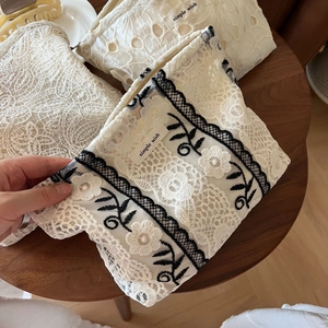 Close-up of beige lace cosmetic bag with floral embroidery and Simple Wish label