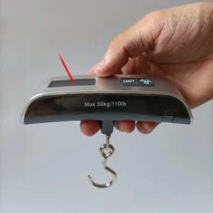 Detail of hand-held digital luggage scale with 50kg capacity and clear LCD display