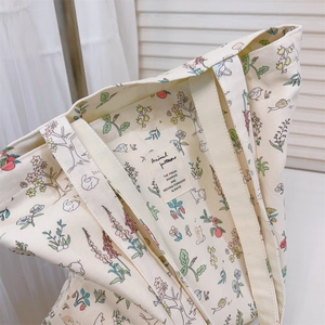 Detail of cream velvet tote bag featuring delicate floral and animal illustration prints