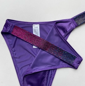 Close-up of purple gradient rhinestones and fabric label on sexy fitness thong