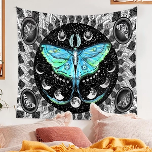 Detail of bohemian tapestry featuring a moon moth design with mandalas on a bedroom wall
