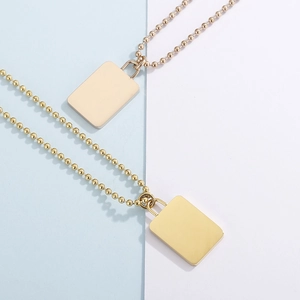 Detailed view of rectangular pendant necklace in gold and silver with ball chain