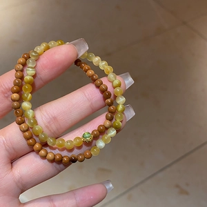 Vue détaillée de bracelets perlés avec œil de chat jaune et perles en bois marron