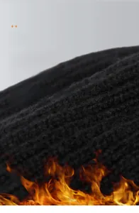 Detail of black thick knit texture showing soft ribbed pattern for winter thermal hats
