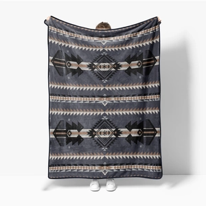 Detail showing the geometric tribal pattern and hemmed edges of a soft flannel throw blanket