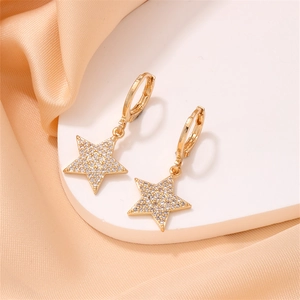 Close-up of gold star drop earrings with sparkling pavé zircons on silk background