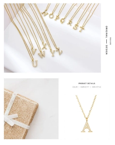 Detail of gold letter pendant with micro-set zircons on a luxury gift box background