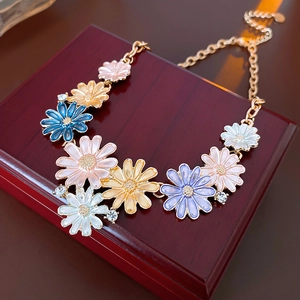 Detail of colorful daisy flower pendants with crystals on a golden chain necklace
