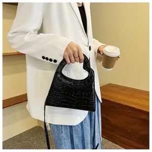 Fashionable black crocodile pattern handbag with unique heart-shaped handle and strap