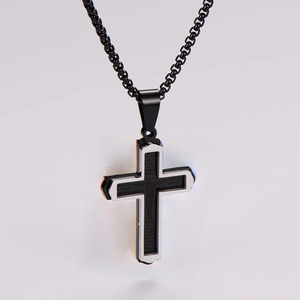 Detail of laser-engraved Spanish Lord's Prayer on a black and silver stainless steel cross