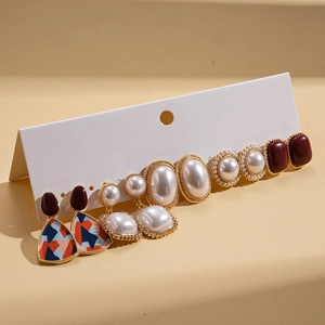 Detail view of pearl and resin geometric earrings arranged on a display card