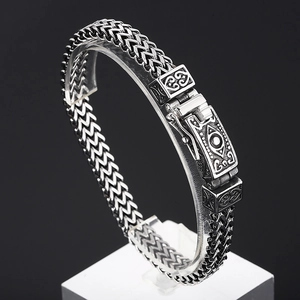 Detailed view of vintage silver steel bracelet with intricate skull eye carvings on clasp