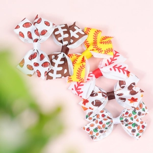 Close-up of six fabric hair bows with rugby and baseball themed patterns for girls