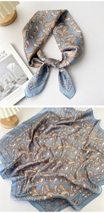 Detail of light blue paisley silk scarf showing soft texture and astronomical patterns