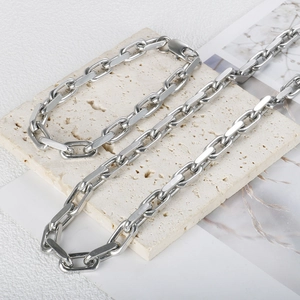 Classic silver stainless steel Cuban link necklace displayed on a cream stone slab
